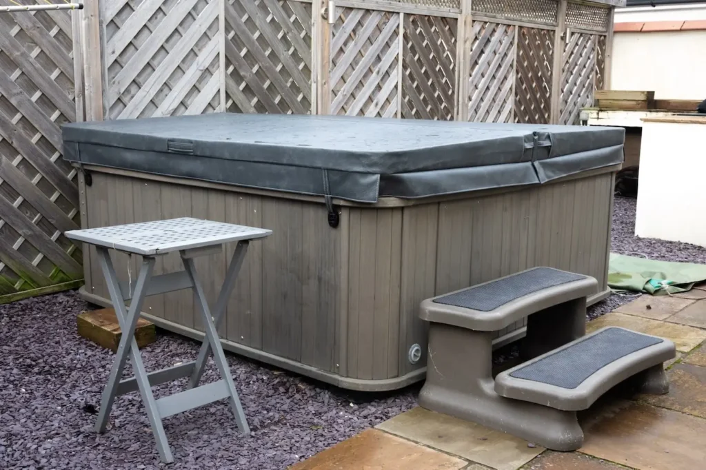 Image showing an old hot tub positioned in a garden in London that should be removed and disposed of.